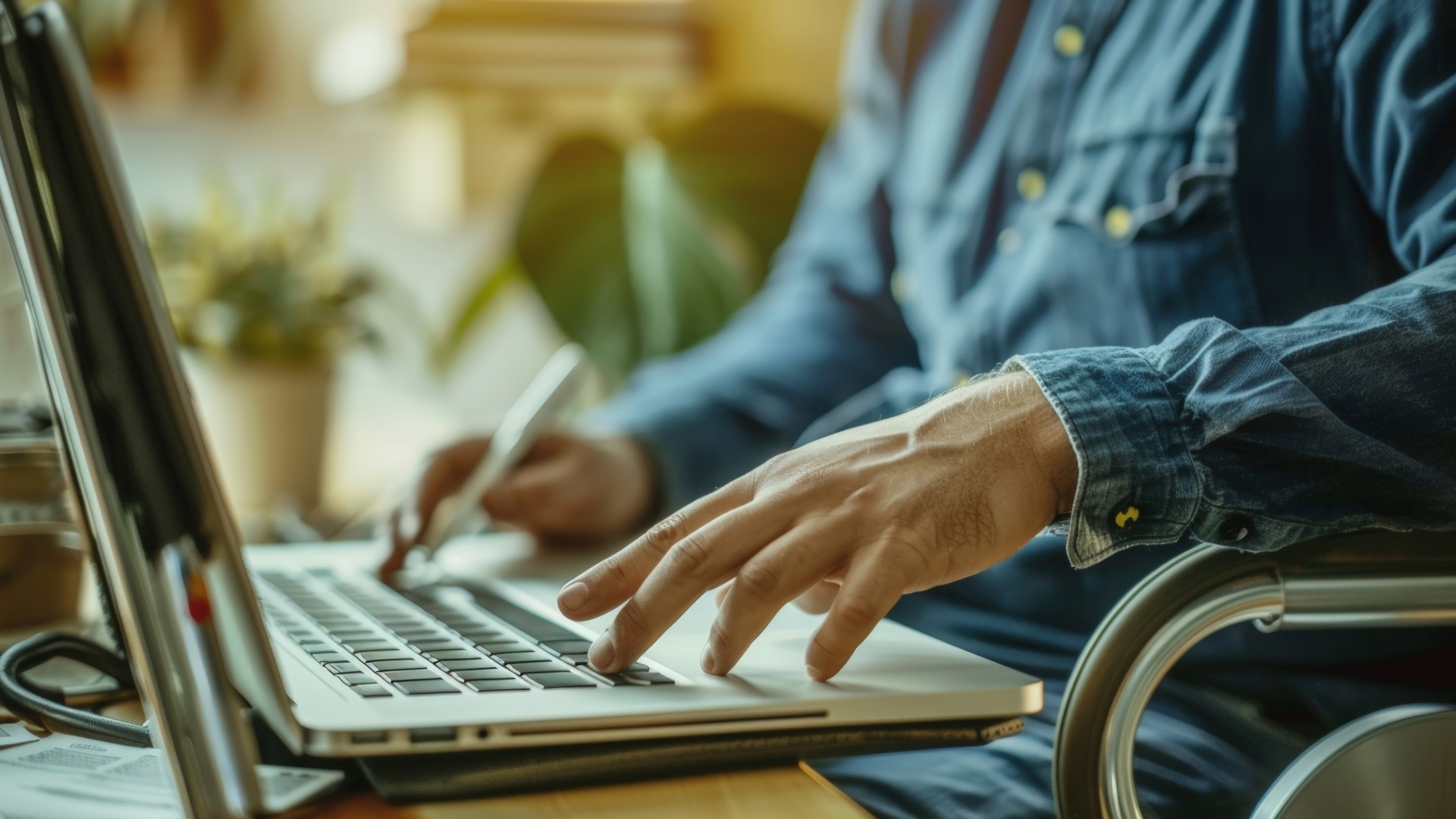 man in wheelchair using laptop with Unified Work Academy